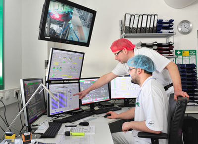 Zwei Horpovel Betriebsmitarbeiter mit Schutzhauben bei einem Test für Reinigungstechnik am Computer