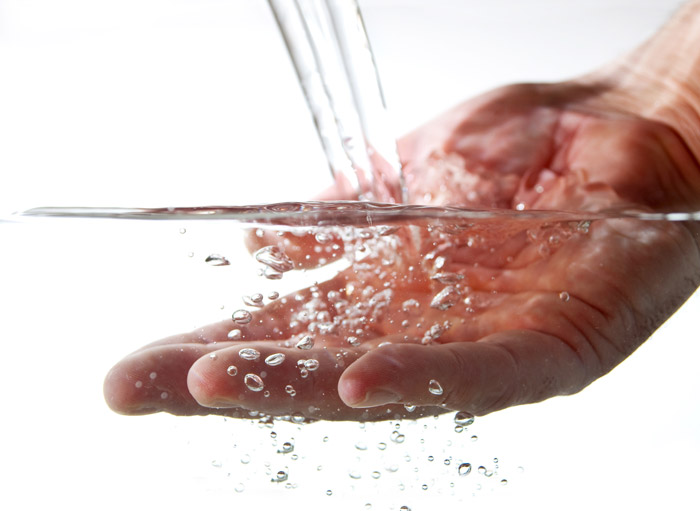 Eine Hand wird in ein sauberes Wasser getaucht